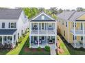 Two-story home boasts a charming double porch, set amid beautifully landscaped lawns and mature trees at 2743 Calico Bass Ln, Johns Island, SC 29455