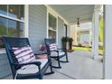Inviting front porch features cozy rocking chairs with stylish cushions, providing a relaxing outdoor space at 2743 Calico Bass Ln, Johns Island, SC 29455