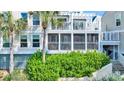 Exterior of the home showcases a screened porch and balcony, surrounded by lush greenery and landscaping at 2933 Atrium Villa Dr # 33, Seabrook Island, SC 29455