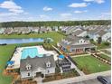 Aerial view of community amenities including a large pool, clubhouse, lake, and green spaces at 301 Dunlin Dr, Summerville, SC 29486