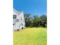 Large grassy backyard is perfect for outdoor activities, with trees in the distance at 3025 Dewitt Ct, Hollywood, SC 29449