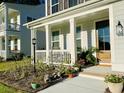Inviting front porch with flower pots, lush plants, and charming details at 3025 Dewitt Ct, Hollywood, SC 29449