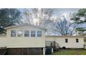 Exterior view showcasing the home's design with multiple windows and an elevated deck area at 334 E Poplar Branch Dr, Moncks Corner, SC 29461