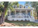 Charming two-story home featuring a welcoming front porch, white railings, and blue lap siding at 3683 Hilton Dr, Johns Island, SC 29455