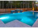 Relaxing pool at night with a colorfully lit waterfall feature and a spacious deck at 3718 Sandy Gate Ln, Mount Pleasant, SC 29466