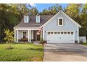 Charming exterior elevation showcasing a two-car garage, dormer windows and a inviting covered front porch at 4263 Hugh Bennett Dr, Johns Island, SC 29455