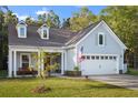 Charming exterior elevation showcasing a two-car garage, dormer windows and a inviting covered front porch at 4263 Hugh Bennett Dr, Johns Island, SC 29455
