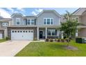 Beautiful two-story home with light grey siding and manicured landscaping on a sunny day at 5138 Preserve Blvd, Ladson, SC 29456
