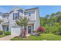Gray townhome with a garage and a landscaped front yard, featuring vibrant pink flowers and lush greenery at 531 Truman Dr, Goose Creek, SC 29445
