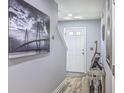 Bright hallway featuring modern decor, hardwood floors, and a view of the front door and stairs at 531 Truman Dr, Goose Creek, SC 29445