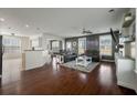 Open-concept living room with hardwood floors, a ceiling fan, and large windows for natural light at 7638 Haywood St, North Charleston, SC 29418