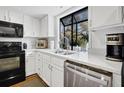 Bright kitchen with white cabinets, stainless steel appliances, and a large window at 764 Summerwind Cir, Edisto Beach, SC 29438