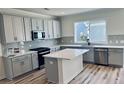 Modern kitchen featuring gray cabinets, a center island, stainless steel appliances, and wood-look flooring at 766 Blueway Ave, Summerville, SC 29486