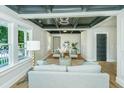 Cozy living room featuring stylish decor, hardwood floors, natural light, and an intricate black and white detailed ceiling at 1011 Ashley Ave, Charleston, SC 29403