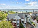 Stunning aerial perspective of brick townhomes with waterfront views, showcasing prime location at 11 Harleston Pl, Charleston, SC 29401