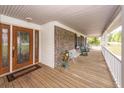 Relax on the spacious front porch with rocking chairs and a view of the yard at 110 Wallace Rd, Goose Creek, SC 29445