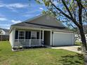 Inviting one-story home featuring a charming front porch and two car garage at 1119 Moss Grove Dr, Moncks Corner, SC 29461