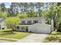 Well-maintained two-story home with an attached garage, mature trees, and a welcoming front porch at 116 Trestlewood Dr, Summerville, SC 29486
