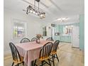 Elegant dining area with contemporary chandelier and a view into a bright, vintage-inspired kitchen at 1211 Eastwood Ave, Hanahan, SC 29410