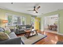 Bright living room features a ceiling fan, hardwood floors, and comfortable grey sofas with backyard view at 1211 Eastwood Ave, Hanahan, SC 29410