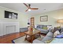 Comfortable living room with fireplace, hardwood floors, ceiling fan, and stylish grey sofa, perfect for relaxing at 1211 Eastwood Ave, Hanahan, SC 29410