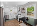Bright kitchen featuring white cabinets, stainless steel appliances, and a view of the outdoor scenery at 13 H St, Charleston, SC 29403