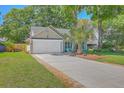 Inviting single-story home with a spacious driveway, beautiful lawn, and a charming, covered front porch at 1315 Old Mill Ln, Mount Pleasant, SC 29464