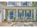 Inviting front porch with rocking chairs, a blue door, and lovely landscaping for relaxing outdoors at 134 Comiskey Park Cir, Summerville, SC 29485