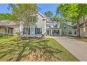 Beautiful two-story home with a well-manicured lawn, mature trees, and a welcoming front porch at 134 Comiskey Park Cir, Summerville, SC 29485