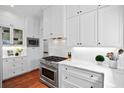 Elegant kitchen boasts stainless steel appliances, including a gas range, complemented by white cabinets and quartz counters at 139 Tradd St # 2, Charleston, SC 29401