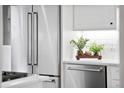 Modern kitchen with stainless steel refrigerator, dishwasher, white cabinets, quartz countertops, and stylish decor at 139 Tradd St # 2, Charleston, SC 29401