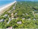 Secluded luxury home surrounded by mature trees near a white sandy beach and waterway at 14 Royal Beach Dr, Kiawah Island, SC 29455