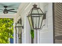 Close-up on classic exterior lantern lights, with a ceiling fan above, complementing the home's design at 1535 Capel St, Mount Pleasant, SC 29466