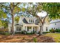 Beautiful home with a cozy front porch, mature trees, and landscaped front yard at 1543 Gemstone Dr, Mount Pleasant, SC 29464