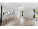 Living room with light colored, laminated floors and white walls, with a partial view into the kitchen at 177 Cady Dr, Summerville, SC 29483