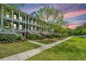 Beautiful multi-story home with covered porches, lush landscaping, and a sidewalk at 2013 Grey Marsh Rd, Mount Pleasant, SC 29466