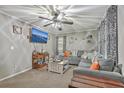 Spacious living room featuring a large gray sectional, ceiling fan, and wall-mounted TV for entertainment at 202 Oak Cir, Walterboro, SC 29488