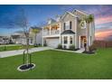 Beautiful two-story home showcases a lovely front balcony, lush lawn, mature palm tree, and a spacious driveway at 204 Honey Horn Dr, Summerville, SC 29486