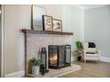 Close-up of a brick fireplace with decorative mantel, hearth accessories, and warm, inviting flames at 2042 Highway 402, Moncks Corner, SC 29461