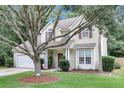 Traditional home with a two-car garage, a front yard with mature trees and lush green lawn, and tasteful landscaping at 2136 Baldwin Park Dr, Mount Pleasant, SC 29466
