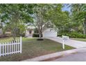 Inviting home with a lush green lawn, a white picket fence, and a freshly paved driveway at 227 Lipman St, Summerville, SC 29483