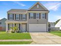 Attractive two-story house with a well-kept lawn, driveway, and welcoming front porch at 243 Donatella Dr, Goose Creek, SC 29445
