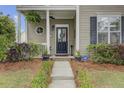 Inviting front porch featuring manicured landscaping, a welcoming door, and charming details at 41 Regency Oaks Dr, Summerville, SC 29485