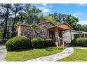 Charming brick home with manicured landscaping, a covered front porch, and a welcoming walkway to the front door at 5447 W Lakeland Dr, North Charleston, SC 29406