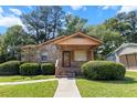 Charming brick home with manicured landscaping, a covered front porch, and a welcoming walkway to the front door at 5447 W Lakeland Dr, North Charleston, SC 29406