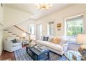 Bright living room with hardwood floors, white sofa and a staircase at 55 Laurens St # 55-A, Charleston, SC 29401