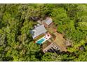Aerial view of an estate with a pool, garden, fire pit and outdoor lounge area surrounded by lush trees at 5680 Dixie Plantation Rd, Hollywood, SC 29449