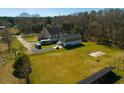 A spacious home and property featuring outbuildings, parking for RV, solar panels, and large grass lawns at 6440 St Anthony Dr, Hollywood, SC 29449