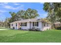 Charming brick home with a lush green lawn and inviting front porch with an orange colored front door at 733 Longfellow Rd, Charleston, SC 29407