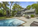Relaxing backyard with a private pool, patio furniture, and a lush green lawn at 739 Wildwood Rd, Charleston, SC 29412